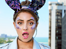 surprised woman with sequined rabbit ears and face glitter